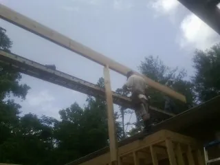 Carpenter setting a ridge beam over a new addition frame — Ice Dam Removal by Roofing Brothers in Mercer Island