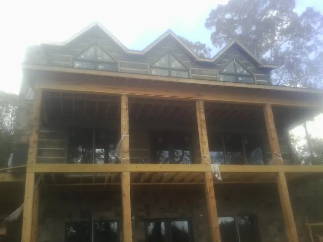 Dormers and porch framing on a large log home under construction — Roof Coating work by our crew in Mercer Island
